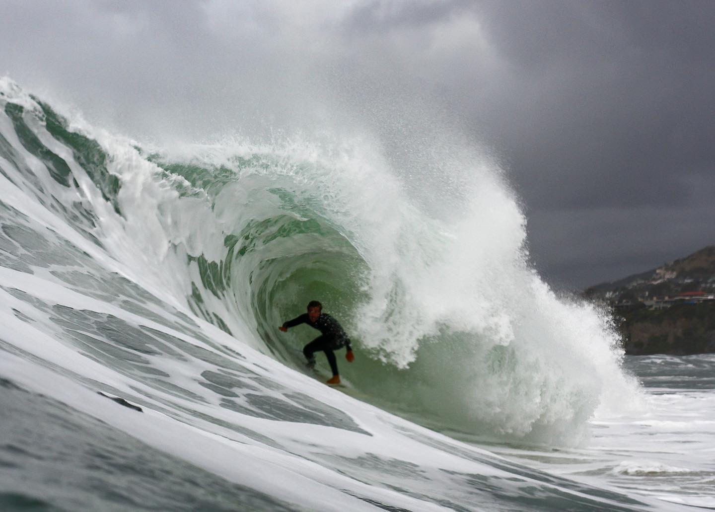 Lucas Taub deep in a heavy barrel under stormy skies